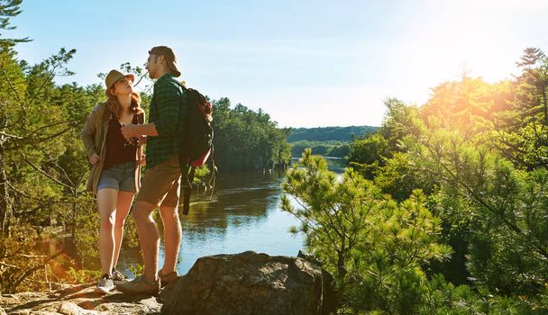 ブルースカイ,ハイキング,カップルは,木,太陽,水で山の冒険休暇で湖の崖にいます. 登山のための川,森または屋外で一緒に旅行休暇でトレッキング,男女. - 写真・画像