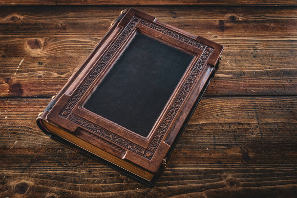 Großes braunes Lederbuch auf Holztisch gelegt - Foto, Bild