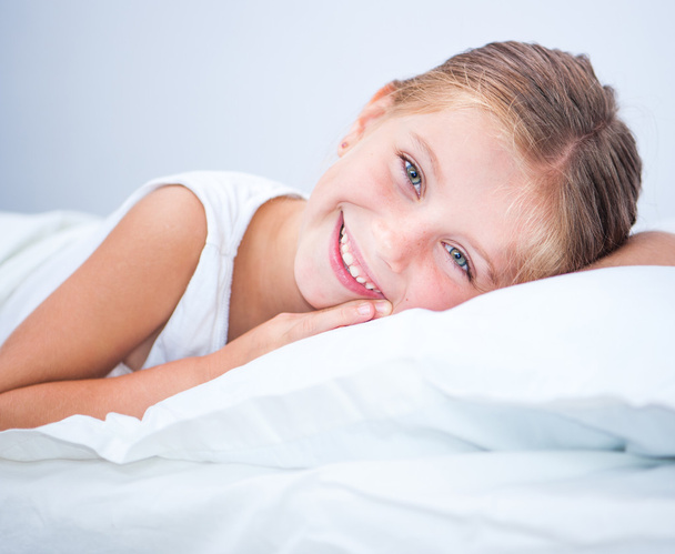 Little smiling girl in  bed - Foto, immagini