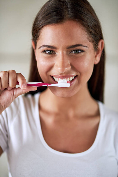 Portré, nő és mosoly fogkefével a fürdőszobában otthon a higiénia és a tiszta fogak. Női személy, arc és boldog fogkrém a friss lehelet vagy illat a száj- és fogászati egészség. - Fotó, kép