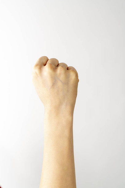 mano femminile trasformata in pugno sfondo bianco Concetto di forza e determinazione - Foto, immagini