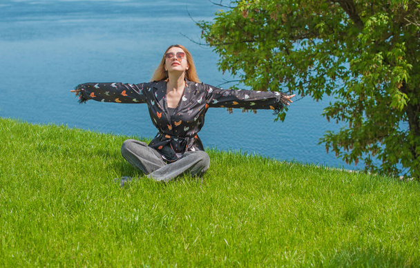 Concepto de curación y meditación de energía, mujer en una hierba que se enfría y descansa afuera - Foto, Imagen