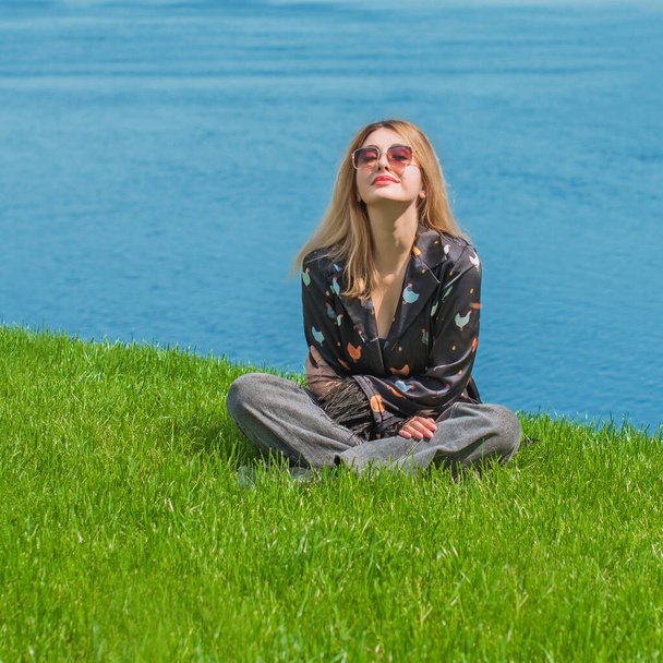 エネルギーヒーリングと瞑想のコンセプト, 芝生を冷やして外で休む女性 - 写真・画像