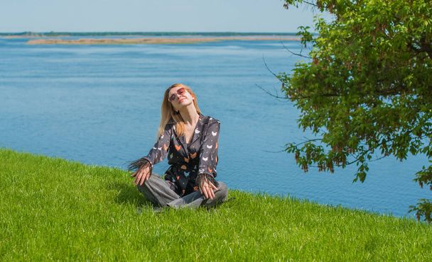 Энергетическое исцеление и медитация концепции, женщина на траве охлаждения и отдыха снаружи - Фото, изображение