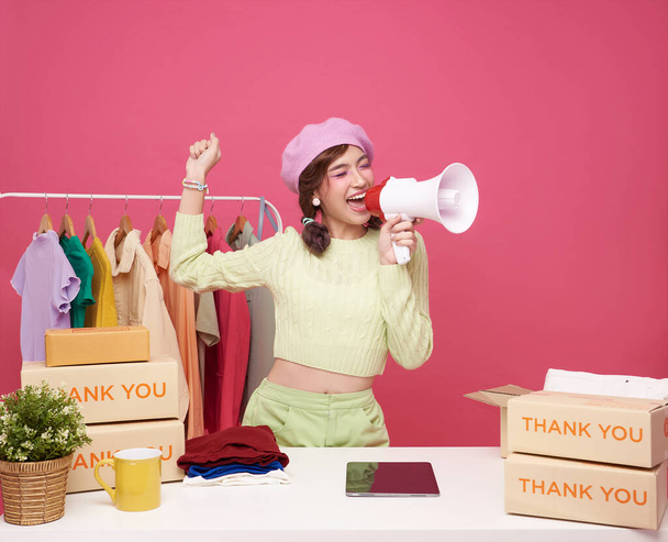 Young asian woman startup small business freelance seller clothing holding megaphone announce promotion sell isolated on pink background, Online marketing and delivery concept - Fotoğraf, Görsel