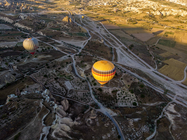 Aerial view of hot air balloons at dawn against the light, flying over the valleys of Cappadocia, 07-08-2019. Turkey - Φωτογραφία, εικόνα