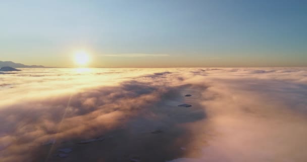 Aamupilven yllä lennetään korkealla. Auringonnousu paistaa kirkkaisiin kerroksiin pörröisiä pilviä, arktinen merivesi ja vuorijono huiput. Luonto tausta täydellinen maisema tapetti - Materiaali, video