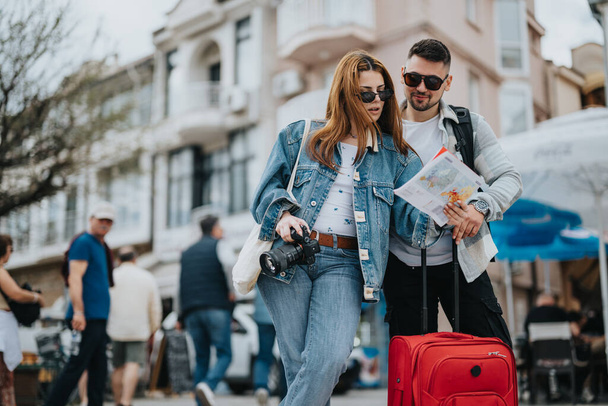 Dois jovens turistas com uma câmera e mapa desfrutar de passeios em uma movimentada cidade ensolarada durante suas férias. - Foto, Imagem
