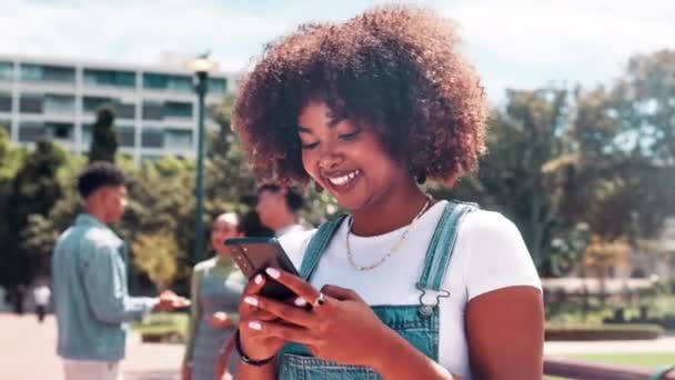 Black woman, student and afro with phone at university for social media, communication or networking in nature. Happy African or female person with smile on mobile smartphone for online chatting. - Footage, Video