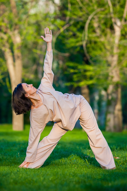 Practicing yoga in the morning, with trees  background - Photo, image