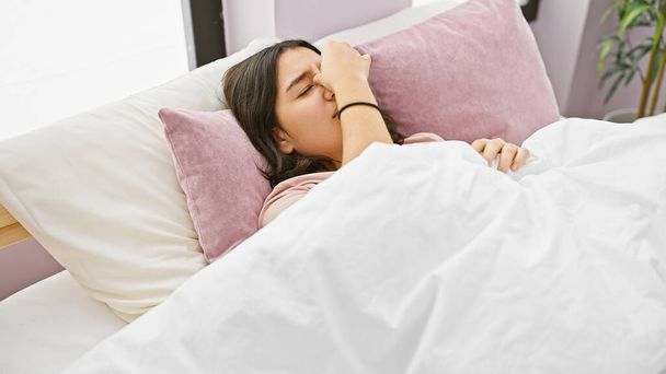 Młoda latynoska kobieta budzi się w przytulnej sypialni, czując się odświeżona - Zdjęcie, obraz