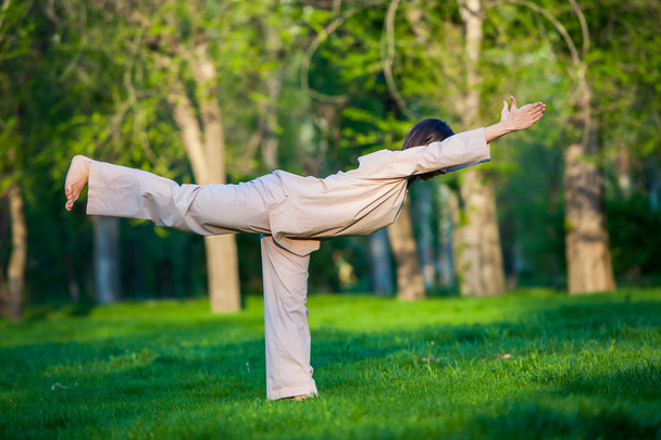 Practicing yoga in the morning, with trees  background - Zdjęcie, obraz