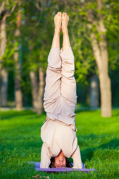 Practicing yoga in the morning, with trees  background - Foto, afbeelding