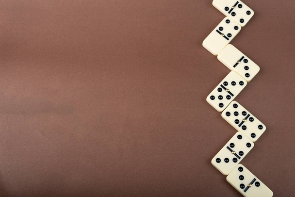 Kahverengi arka planda domino taşları. Beyaz Kemik Tahta Oyunu. - Fotoğraf, Görsel