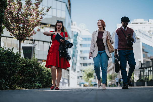 Un grupo de colegas confiados en atuendos de negocios casuales caminan al aire libre, representando una cultura creativa de startups.. - Foto, imagen