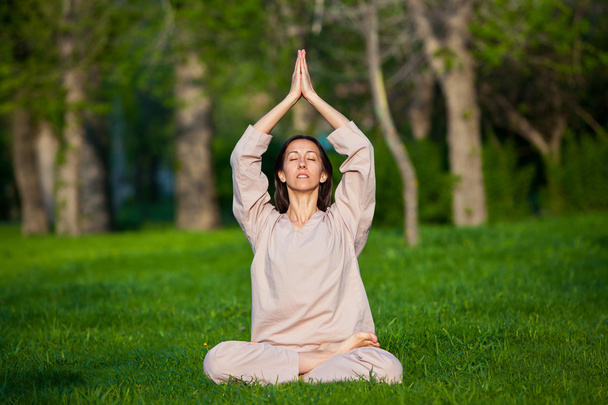 Practicing yoga in the morning, with trees  background - Foto, Bild