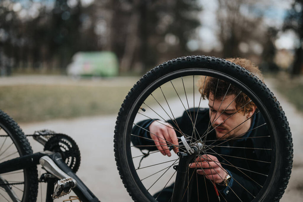 Ένας επιχειρηματίας κάνει ένα διάλειμμα για να επισκευάσει το ποδήλατό του στην ηρεμία ενός πάρκου, ανάμειξη επιχειρήσεων και αναψυχής. - Φωτογραφία, εικόνα