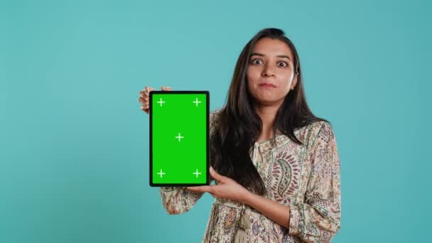 Portré indiai nő csinál befolyásoló marketing segítségével zöld képernyős tabletta, elszigetelt stúdió háttér. Mosolygó személy kezében üres másolási hely mockup eszköz, A kamera - Felvétel, videó