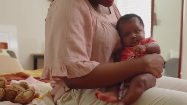 Oříznutý záběr roztomilé africké americké dítě dívka sedí v matčiných rukou doma - Záběry, video