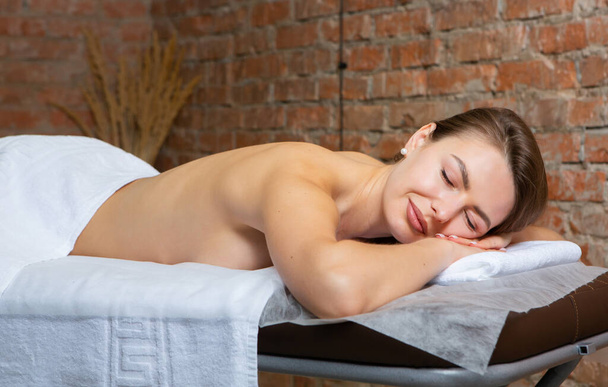 Mujer joven recibiendo un masaje de espalda en un salón de spa. Concepto de tratamiento de belleza. - Foto, imagen