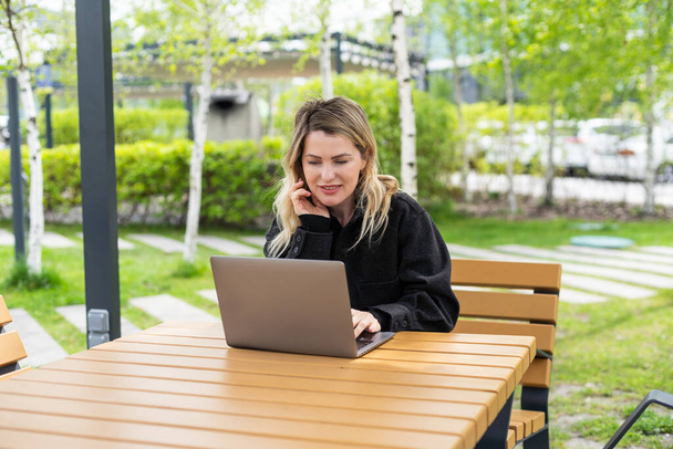 Молодая женщина с ноутбуком снаружи. Высокое качество фото - Фото, изображение