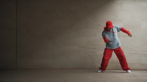 Profesyonel Asyalı hipster gri arka planlı break dansçı performansı sergiledi. Çekici bir sokak dansçısı şık kıyafetler giyerken hareketli hareketler yapar. Açık hava sporu 2024. Uzayı kopyala Yumuşak bir şekilde.. - Video, Çekim