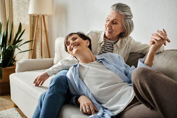 Duas idosas sentadas em um sofá, compartilhando um momento de companheirismo e amor. - Foto, Imagem