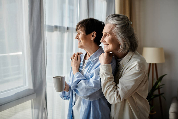 Δύο ηλικιωμένες γυναίκες παρατηρούν ειρηνικά τη θέα έξω. - Φωτογραφία, εικόνα