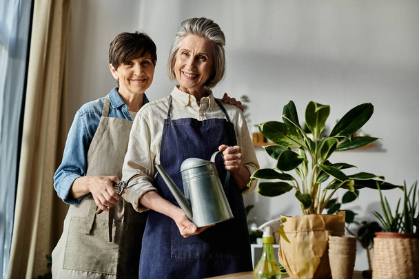 Twee vrouwen in schorten die samen een potplant verzorgen.. - Foto, afbeelding