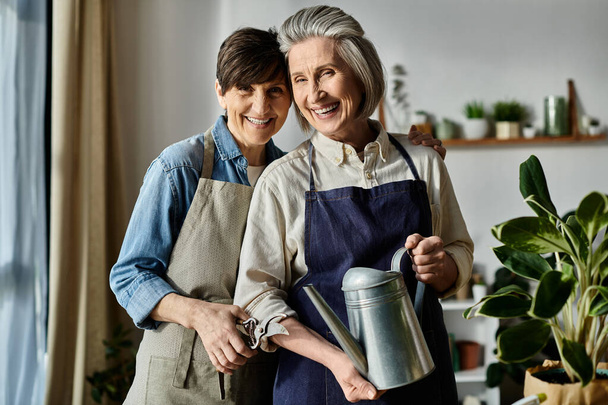 Две женщины в фартуках стоят вместе на кухне. - Фото, изображение