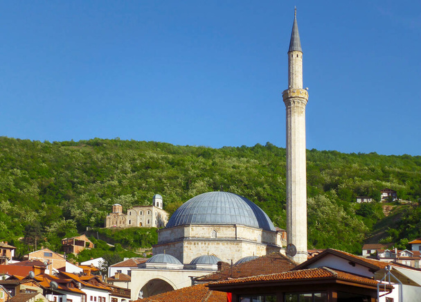 Minarete de Sinan Pasha Mezquita con Iglesia del Santo Salvador en la Colina de Fondo, Ciudad de Prizren, Kosovo - Foto, Imagen