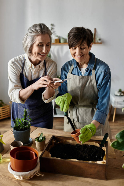Due donne in grembiuli che curano un giardino con cura e unità. - Foto, immagini