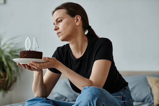 Woman finds solace holding cake on bed. - Fotoğraf, Görsel