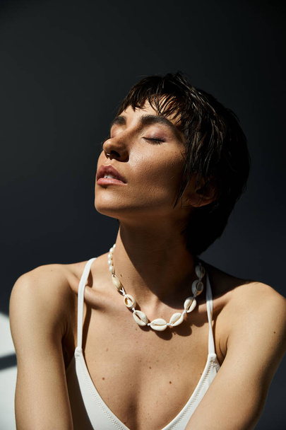 Stylish woman in white top showcases necklace. - Φωτογραφία, εικόνα
