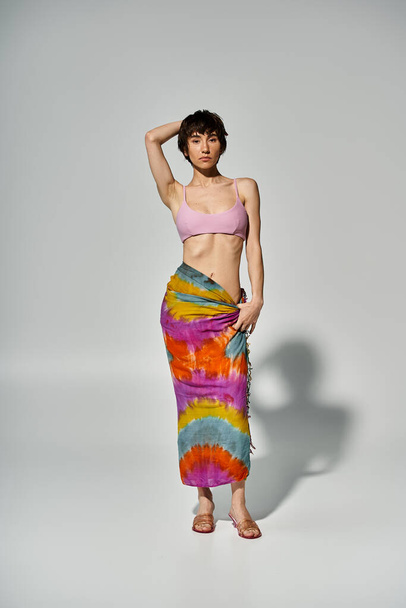 Stylish young woman posing elegantly in a colorful tie dye skirt. - Фото, зображення
