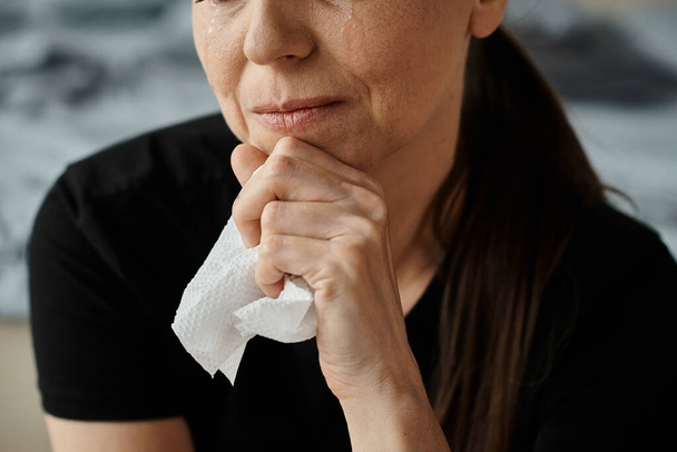 Middle-aged woman holding a tissue in her hand, showing emotional vulnerability. - Foto, Imagen