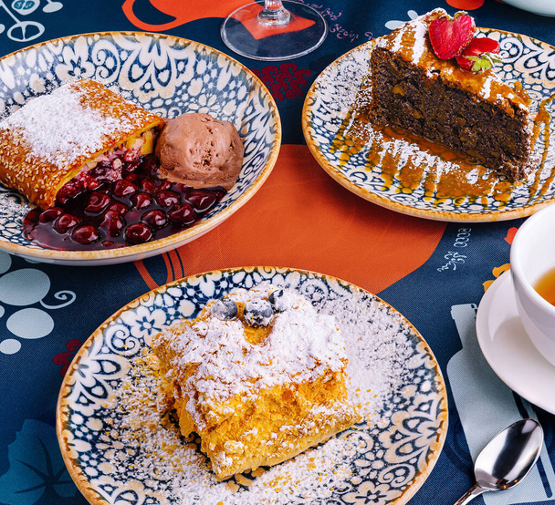 Verleidelijke weergave van verschillende desserts geserveerd elegant op een levendige tafel setting - Foto, afbeelding