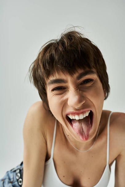 Young woman playfully sticking out her tongue. - Foto, Imagen