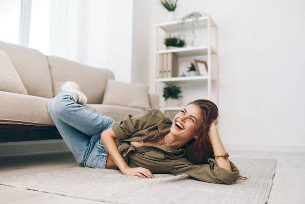 Comfortabel wonen: vrouw ontspannen op gezellige bank in modern appartement - Foto, afbeelding
