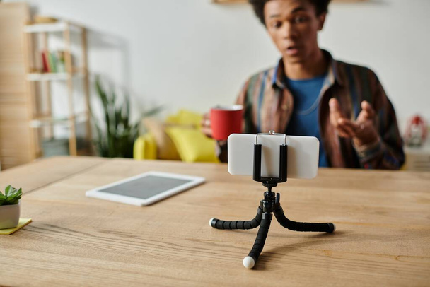 Young African American male blogger recording himself on phone on tripod. - Foto, immagini