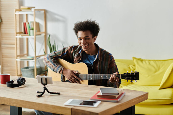 A young man strums his acoustic guitar in a cozy living room. - Zdjęcie, obraz