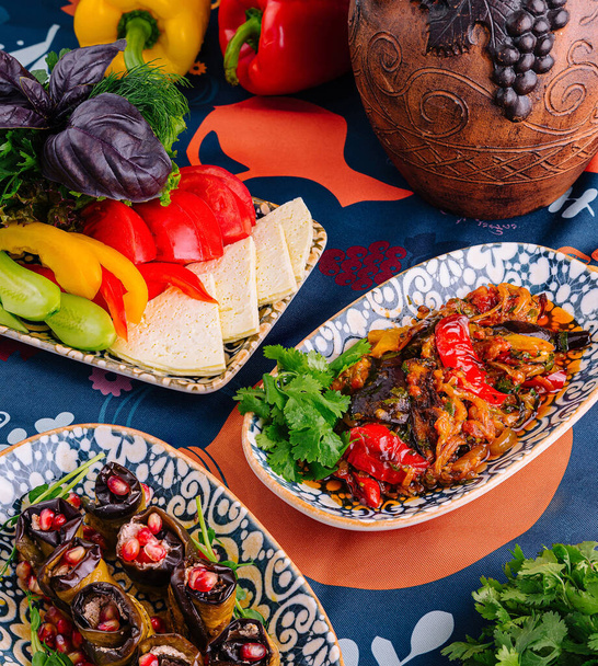 Piatti vibranti di un pasto mediterraneo disposti su una tovaglia decorativa - Foto, immagini