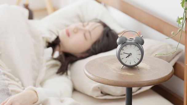 Uma mulher que desliga o alarme e volta a dormir - Foto, Imagem
