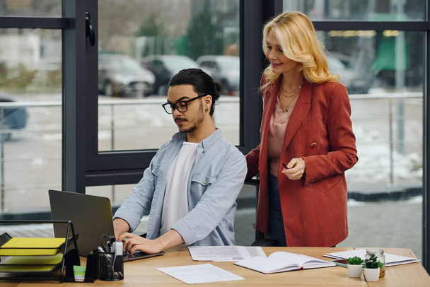 Man en vrouw werken aan een laptop in een kantoor. - Foto, afbeelding