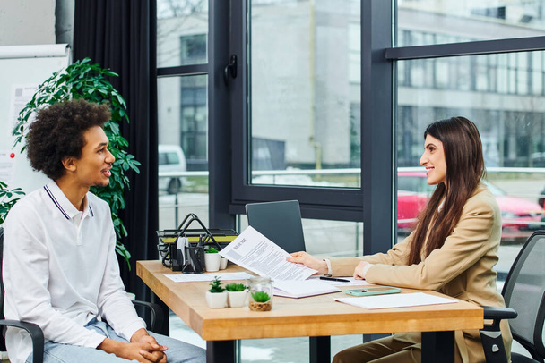 Hombre y mujer profesional discuten en el escritorio en un entorno de oficina moderno. - Foto, Imagen