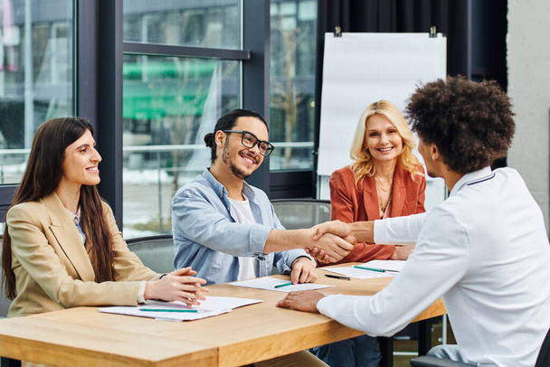 Başarılı bir ağ oluşturma oturumu sırasında bir grup iş arayan bir masada el sıkışıyor. - Fotoğraf, Görsel