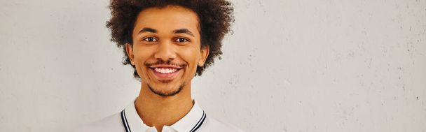 Smiling man with curly hair in front of white background. - Photo, Image