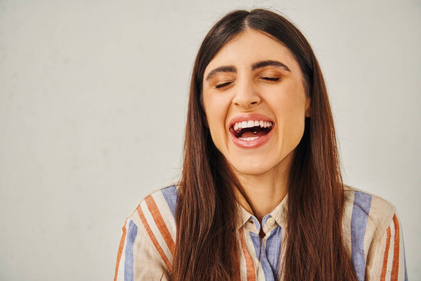 Una giovane donna con la bocca aperta, ridendo gioiosamente. - Foto, immagini