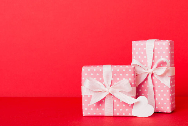 gift box with red bow and red heart on colored background. Perspective view. Flat lay. - Foto, immagini