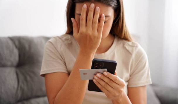 Credit card cloning fraud. Shocked girl finds out that her credit card was cloned and her bank account emptied. Digital theft and cyber security concept. - Photo, Image